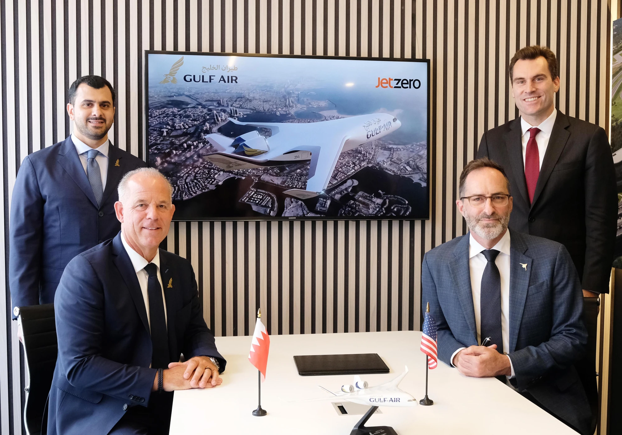 Gulf Air and JetZero signatories seated at a table, with the Z4 concept rendering on the screen behind them.